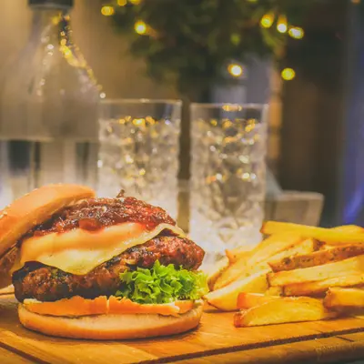 Burger served with fries on a wooden board