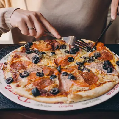 Pizza with salami and black olives