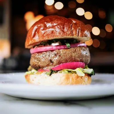 Beef burger with red onion on a brioche bun